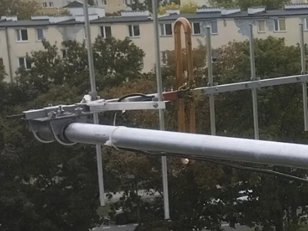 Koniec bomu anteny: płaskownik łączący podporę z bomem, reflektor i miedziany dipol pętlowy, wzdłuż rury biegnie kabel