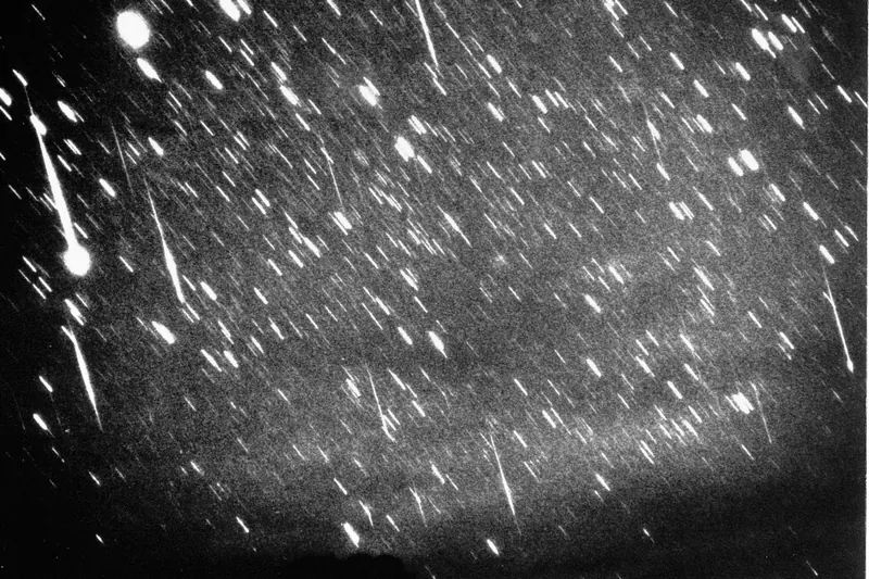 Czarno-białe zdjęcie nieba gęsto pokrytego smugami meteorów podczas burzy Leonidów w 1966 roku