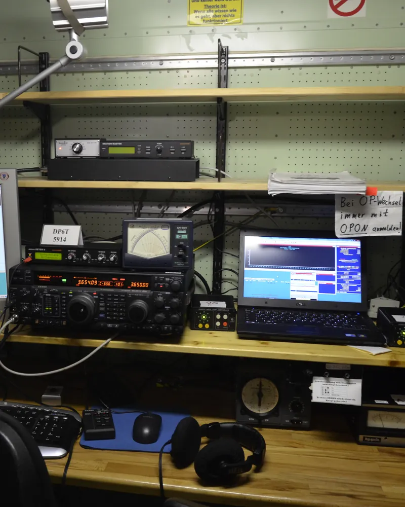 Stanowisko stacji contestowej: transceiver KF, dwa monitory z programem do logowania, słuchawki, mikrofon i manipulator na biurku